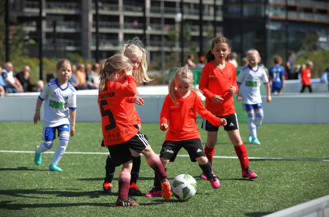 Små jenter i Åsane Fotball drakt som spiller fotball